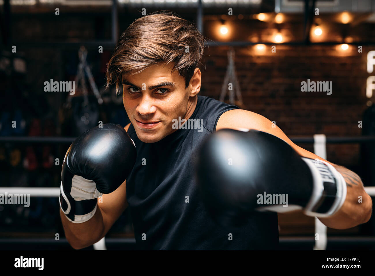 Close up of a young male boxer with boxing gloves punching towards ...