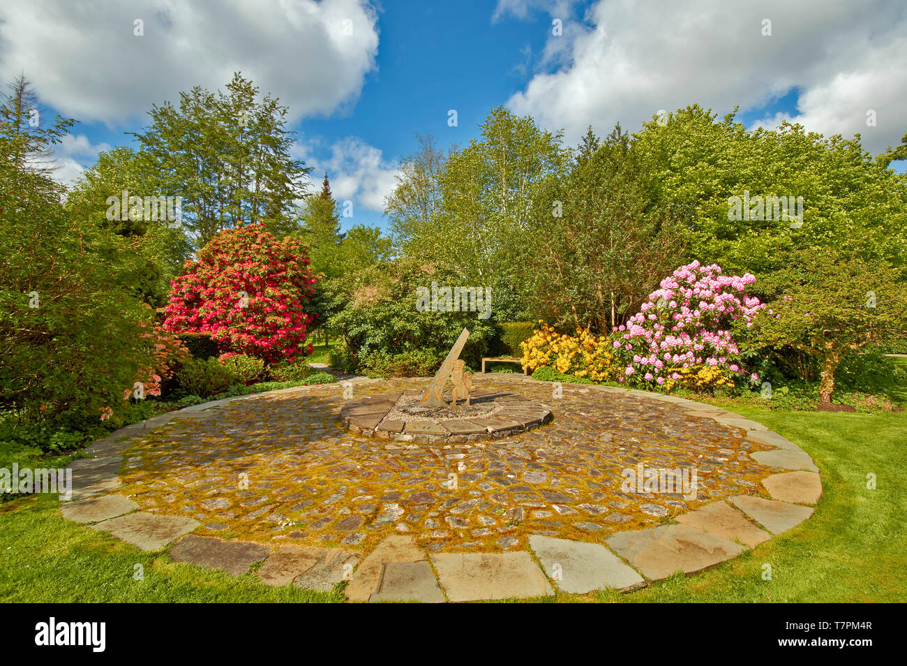 ATTADALE GARDENS STRATHCARRON WESTER ROSS SCOTLAND  IN SPRINGTIME WITH LARGE  SUN DIAL AND A WILDCAT HOLDING THE GNOMON Stock Photo