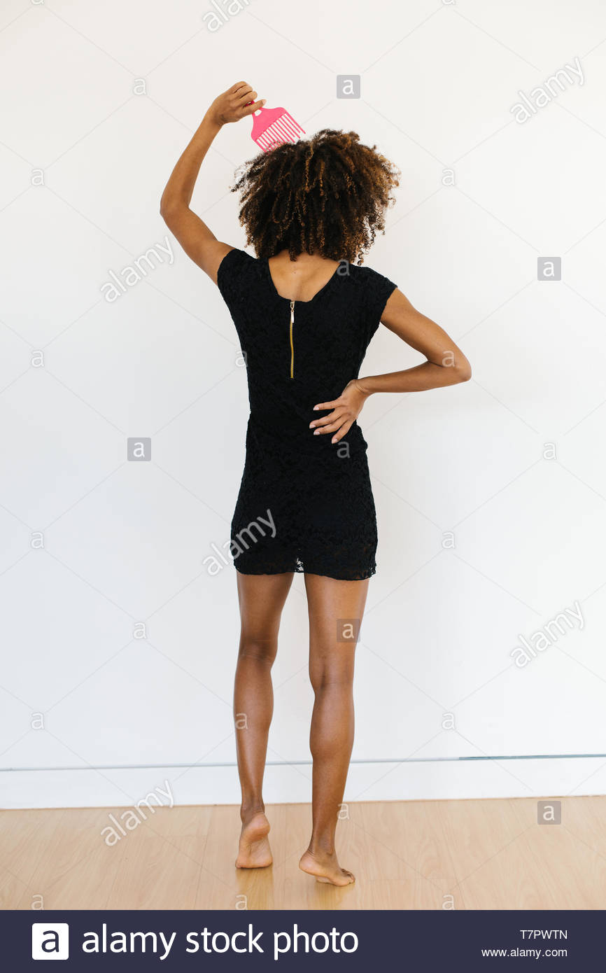 Back View Of Afro Hairstyle Woman Using Comb For Detangle Her