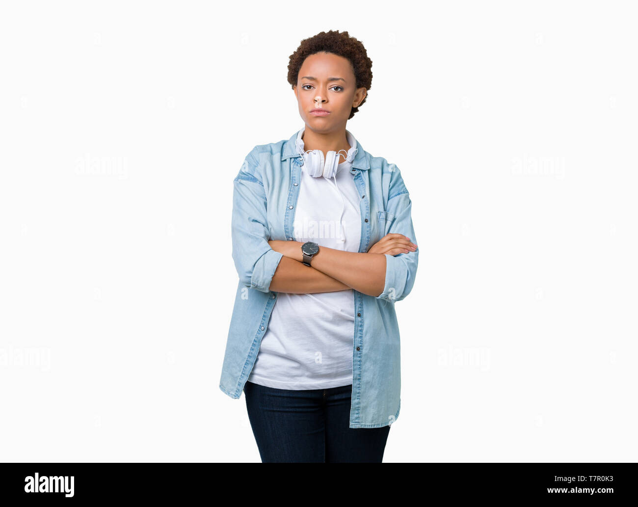 Young african american woman wearing headphones over isolated background skeptic and nervous, disapproving expression on face with crossed arms. Negat Stock Photo
