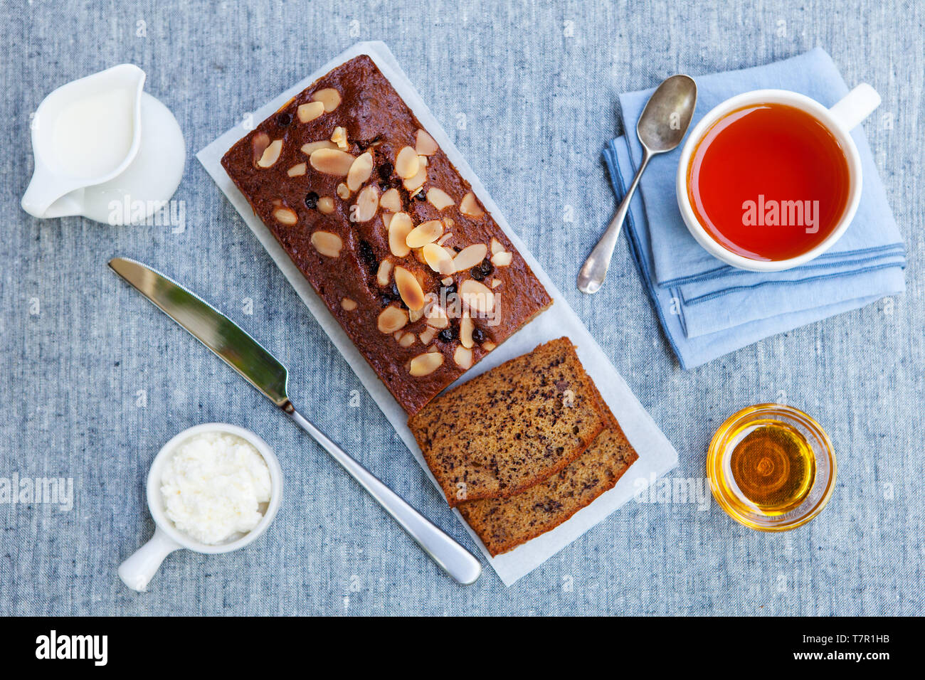 Banana, carrot, apple cake, loaf with chocolate and cup of tea on grey textile background. Top view. Stock Photo