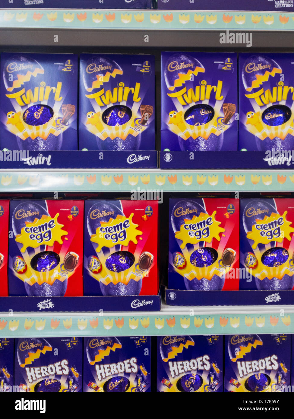 Exeter, Devon , England, March, 14, 2019: A UK supermarket filled shelves selling chocolate Easter Eggs. Lots of purple and red in the image, vertical aspect Stock Photo