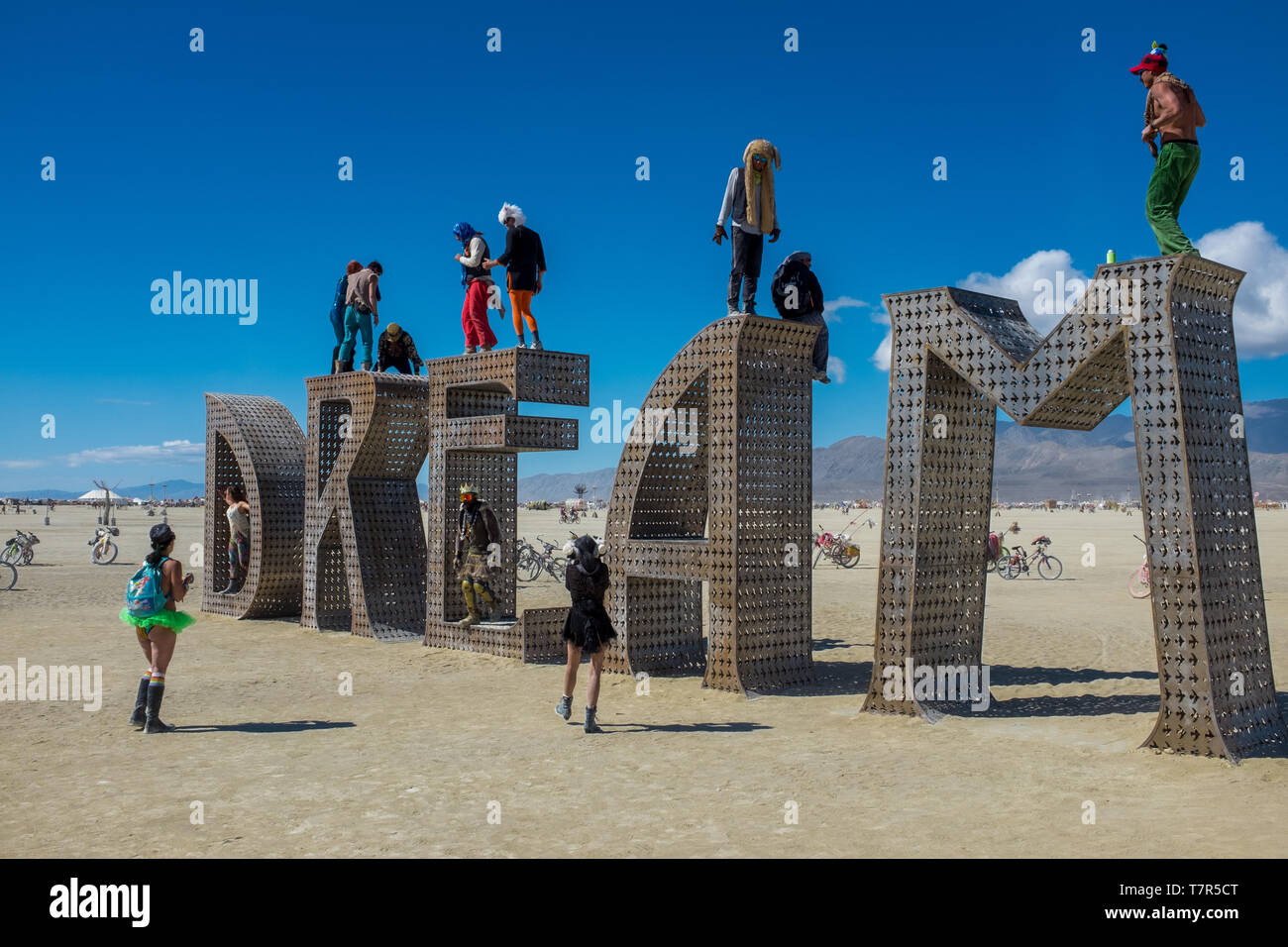 Burning Man, Nevada, USA, September, 6, 2015: Attendees at Burning Man festival standing on and around an artwork of letters that spell out the word, DREAM, against a bright blue sky.gg Stock Photo