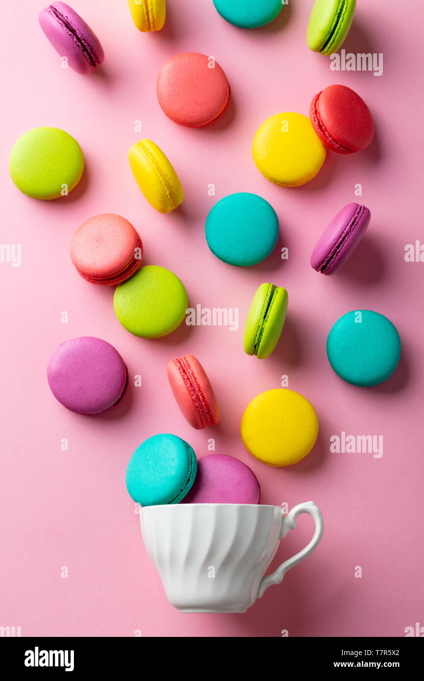 Macaroons dessert with a white cup on pink pastel background. Flat lay composition. Top view. Stock Photo