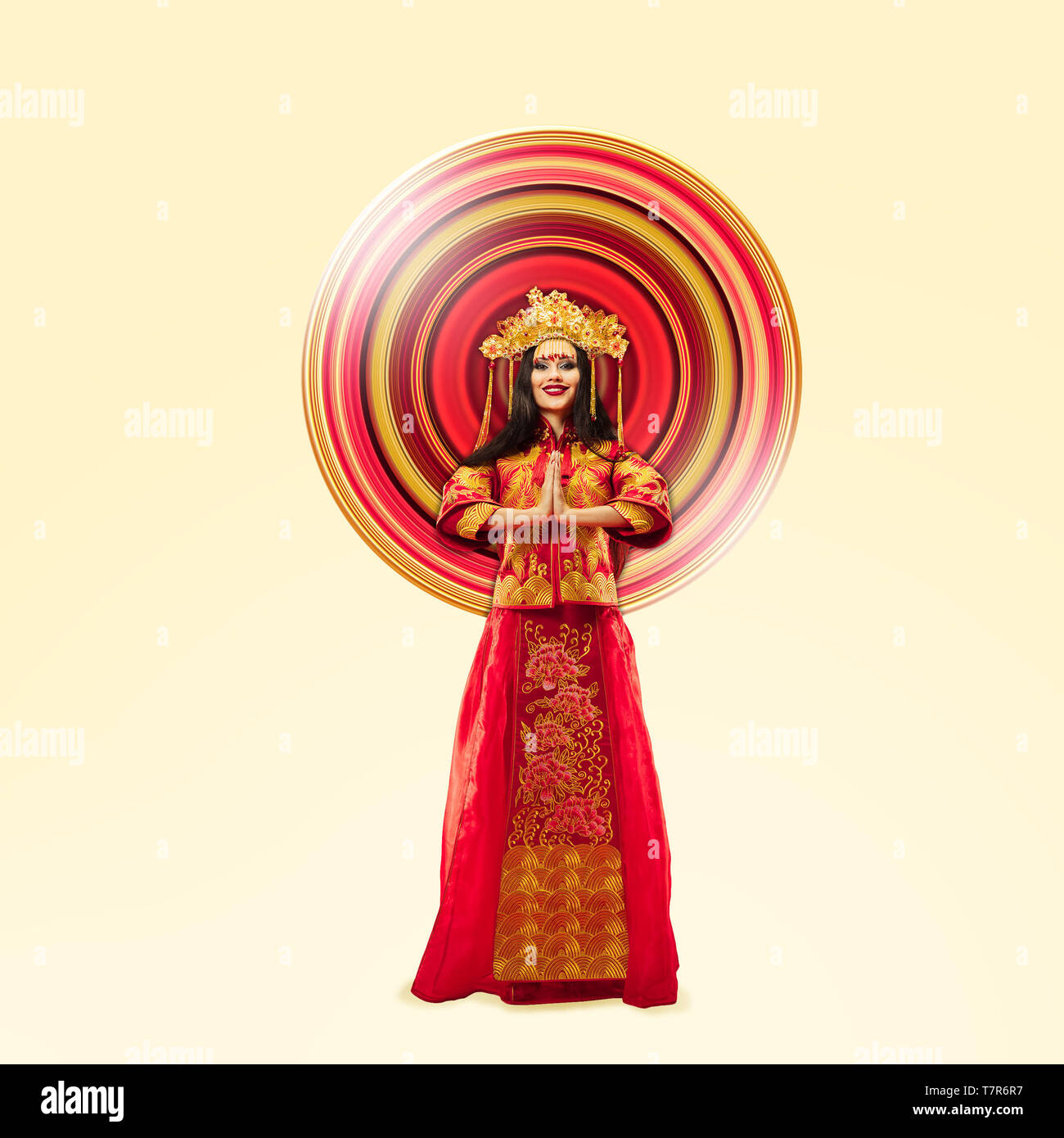 Woman standing in red and gold traditional costume isolated on yellow ...