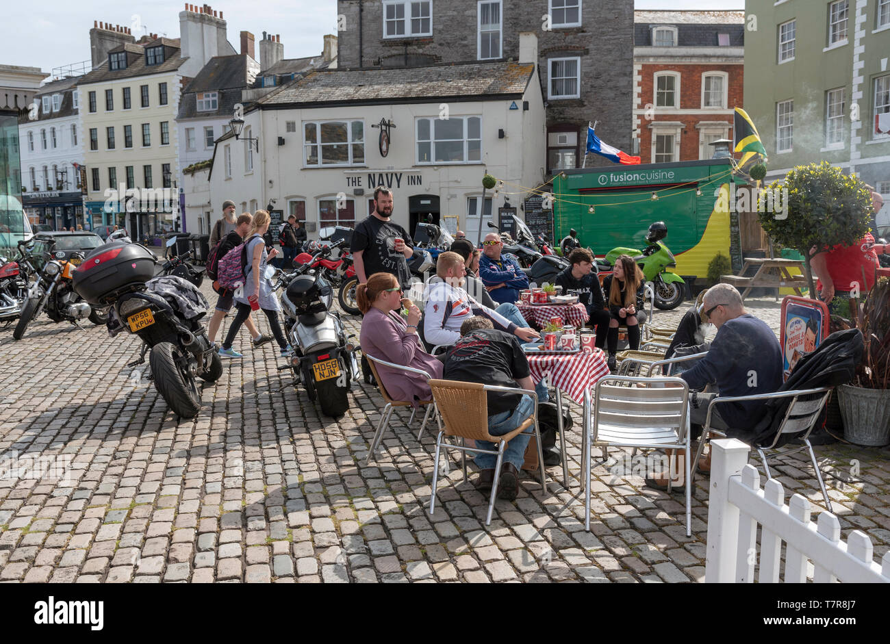 Plymouth, Devon, England, UK. May 2019.  Bikers seated with their machines close by on the Barbican waterfront a popular meeting place for riders Stock Photo
