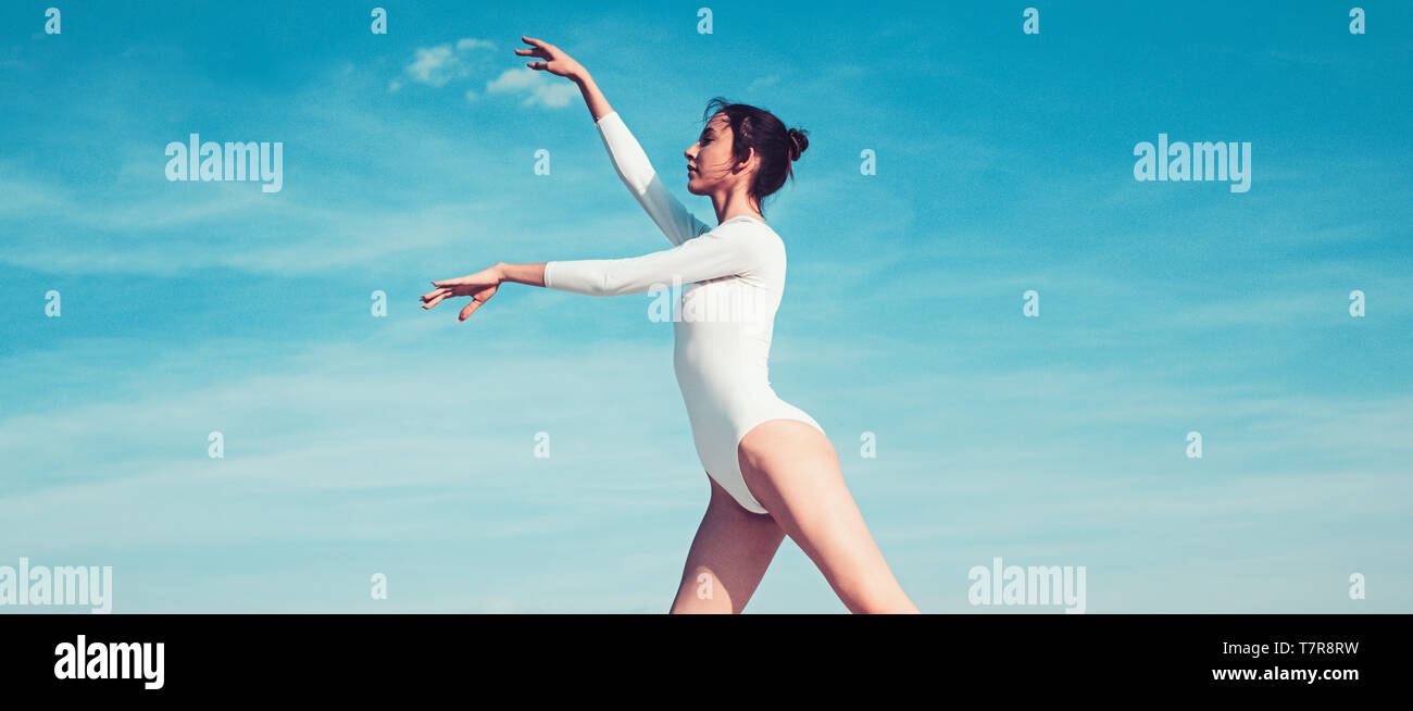 I need to practice more. Practicing art of classical ballet. Young ballerina dancing on blue sky. Cute ballet dancer. Pretty girl in dance wear Stock Photo