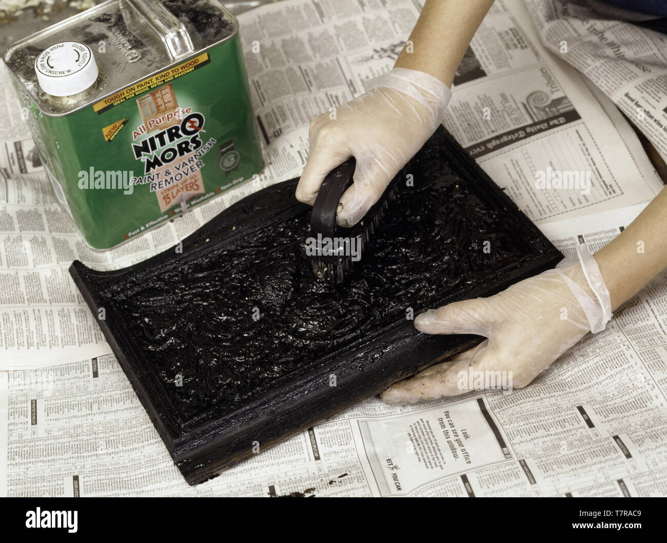 Hands removing old paint from fireplace front Stock Photo Alamy
