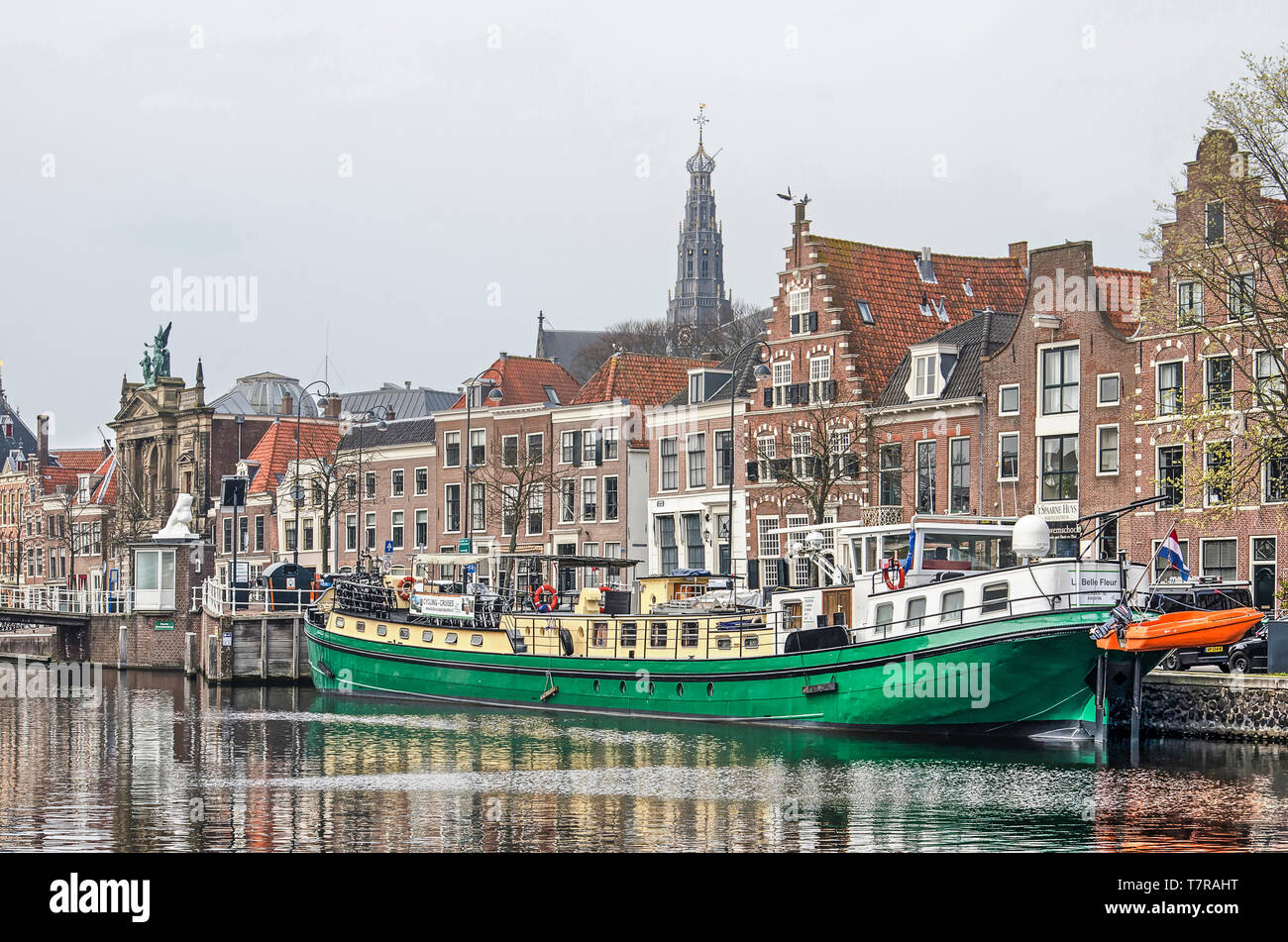 Haarlem, The Netherlands, April 2, 2019: View of the riverfront of the river Spaarne with historic houses, a moored inland barge and in the distance t Stock Photo