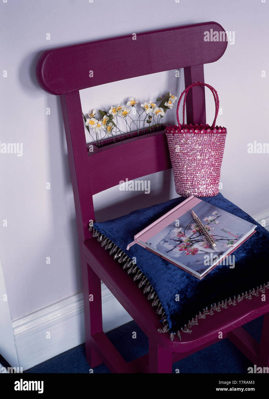 Purple painted chapel chair decorated with faux flowers Stock Photo
