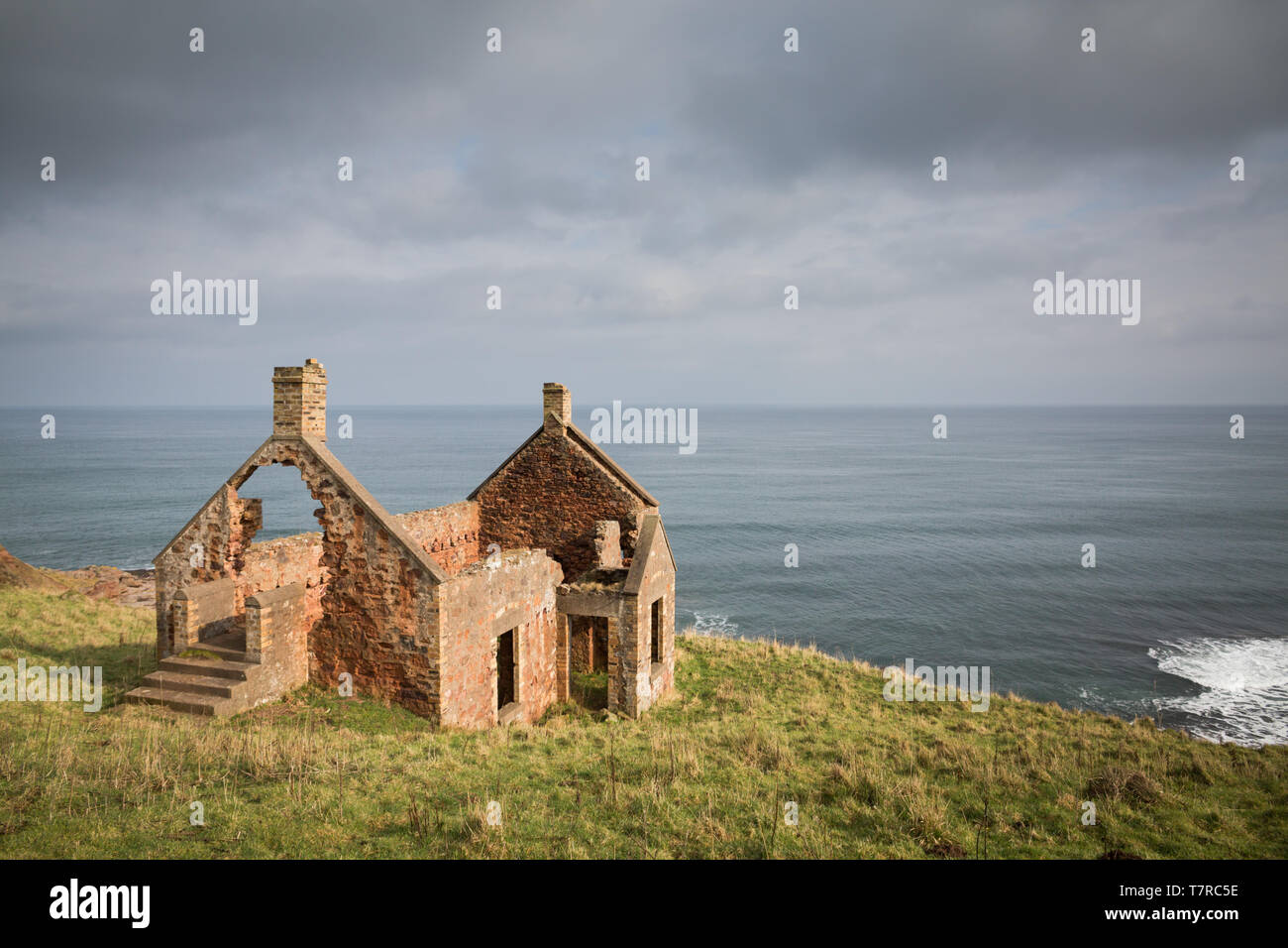 An abandoned red brick cottage on the Berwickshire coast of Scotland overlooking the North Sea. Stock Photo