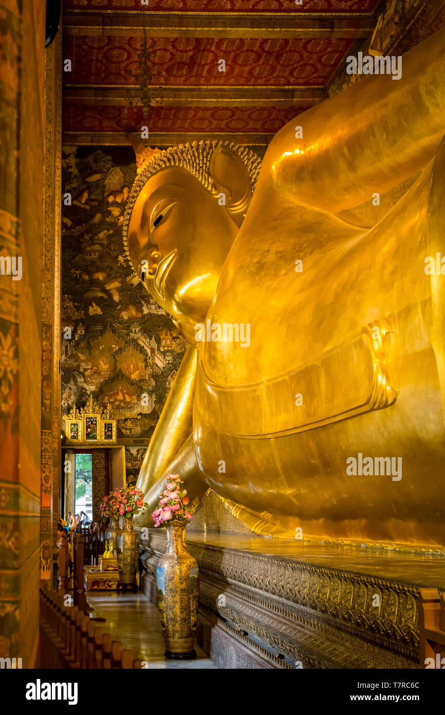 Golden head and body of the Reclining Buddha statue in Wat Pho, Bangkok, Thailand Stock Photo