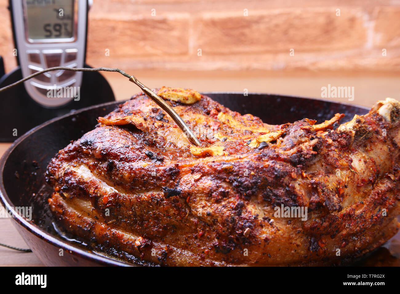 Grilled Steak in a pan and Wireless Remote Digital Cooking Food Probe Meat Thermometer For Grill on a black background. Copy space. Stock Photo