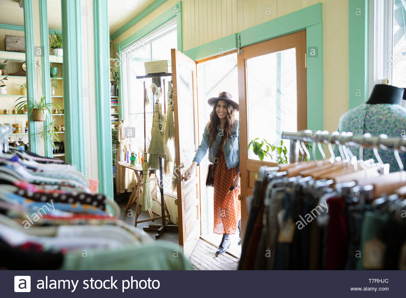Woman opening door of vintage clothing shop Stock Photo Alamy