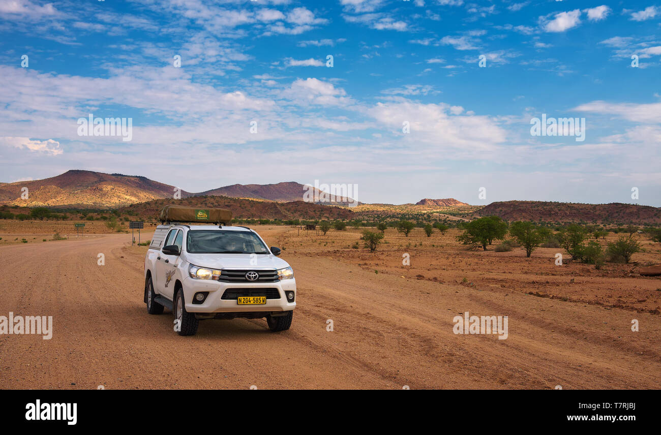 4x4 rental car equipped with a roof tent driving through Damaraland in