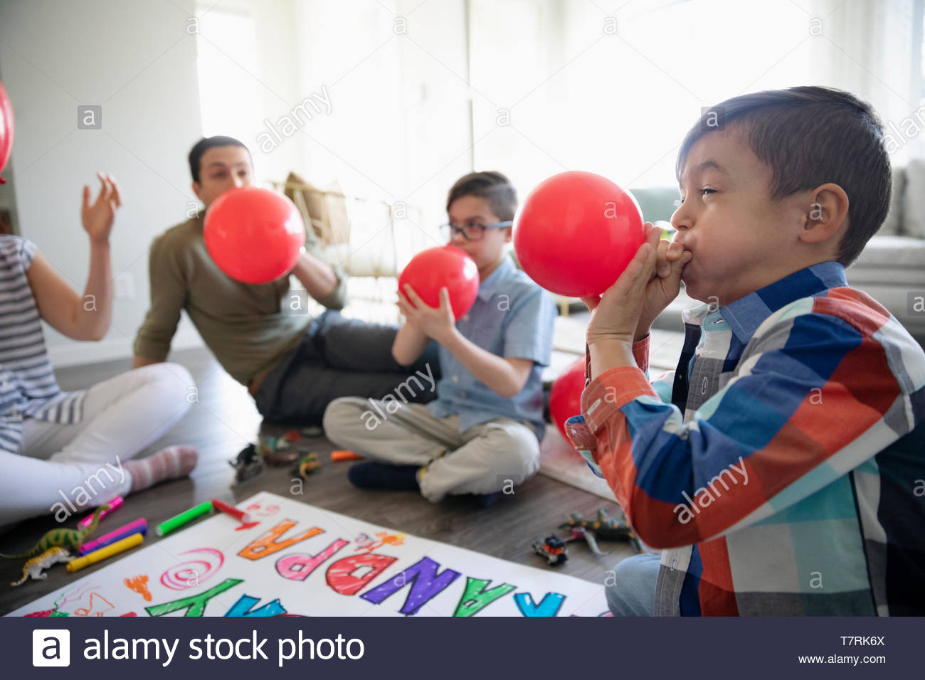 Family blowing up birthday balloons Stock Photo Alamy