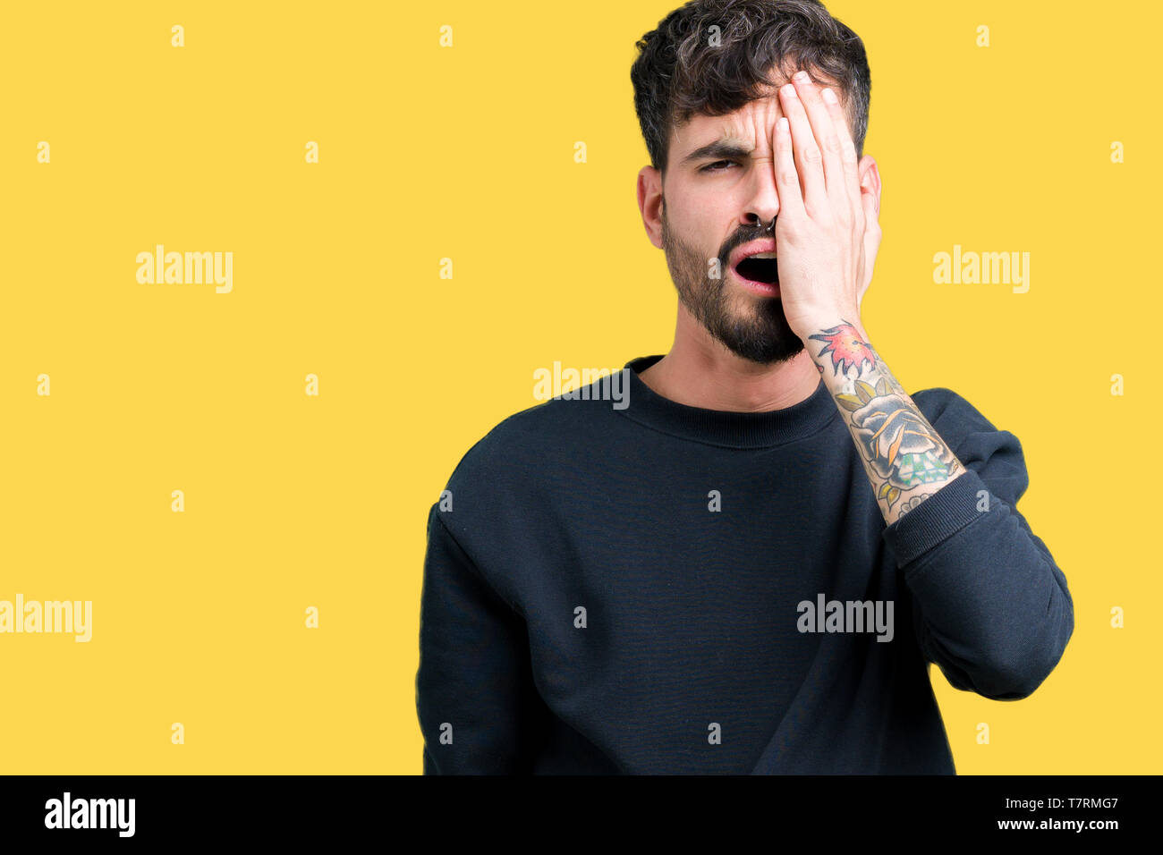 Young handsome man over isolated background Yawning tired covering half