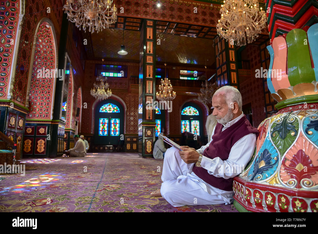 An elderly man seen reading a Quran inside a shrine on the second day ...