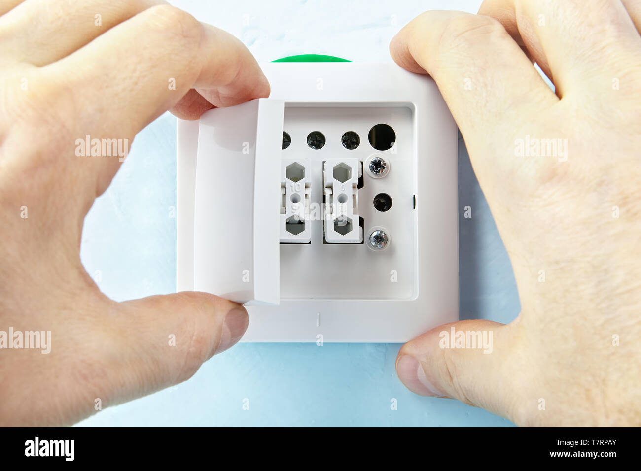 Electrician is putting buttons on european standard light switch, electrical installation. Stock Photo