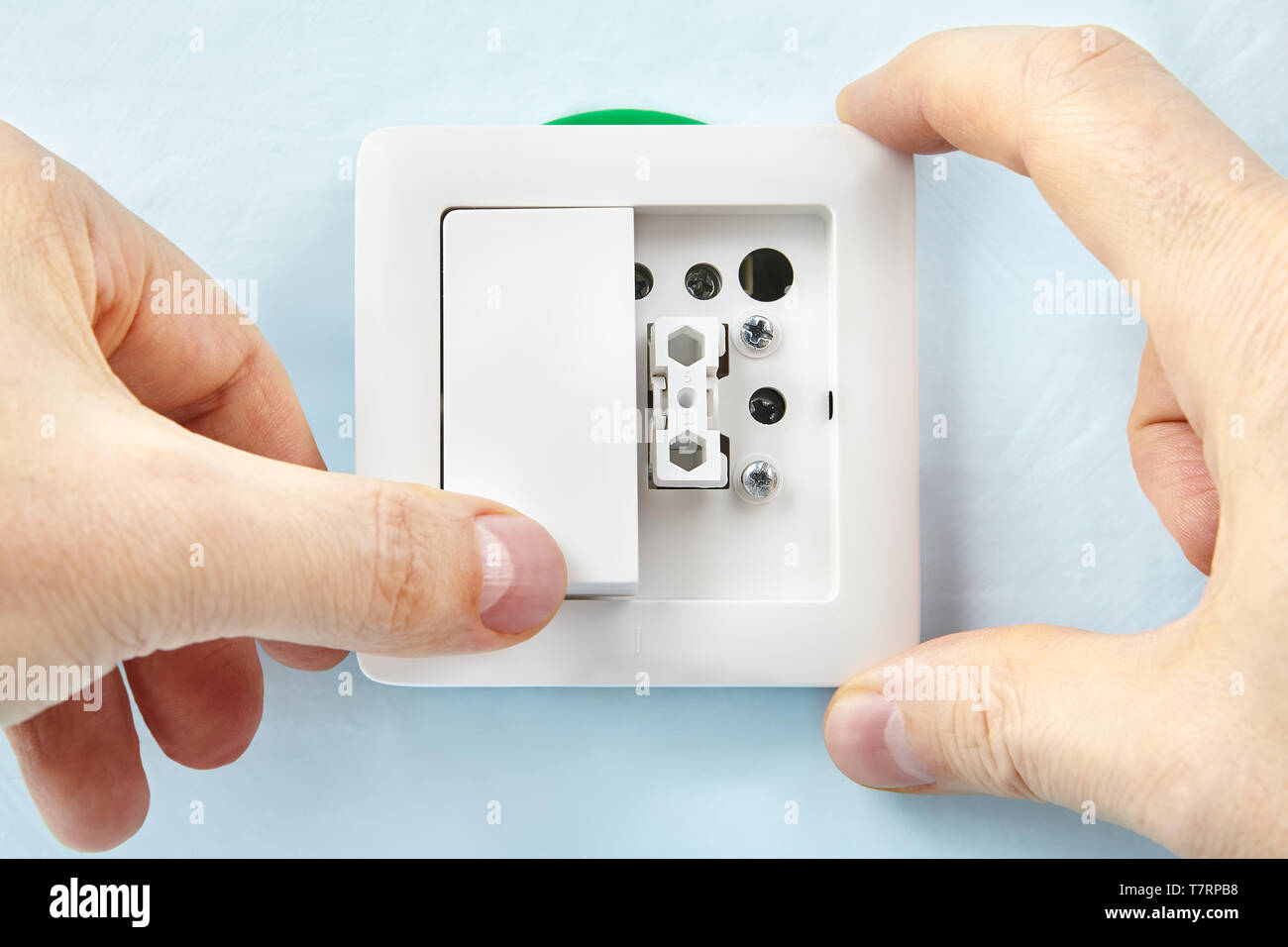 Electrician is making new light switch putting on new button, electric