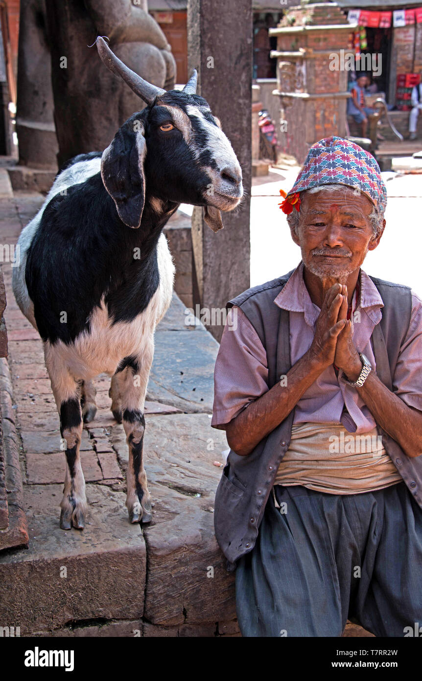 Elderly man with his goat greeting visitors to a courtyard in a Nepalese village Kathmandu, Nepal Stock Photo