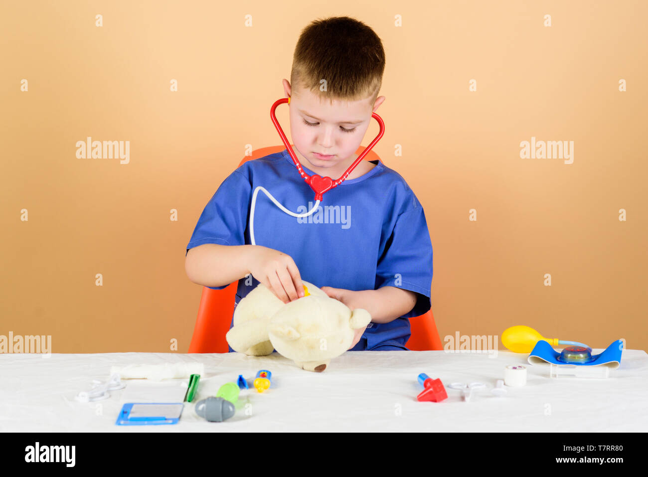 Health care. Kid little doctor busy sit table with medical tools