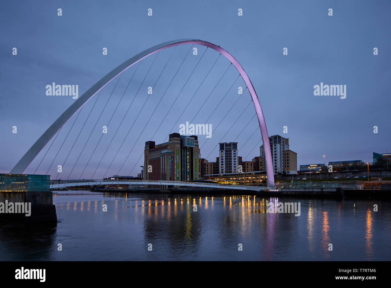 Iconic Newcastle upon Tyne Quayside waterfront landmark Millennium Bridge crossing the river Tyne and converted mill warehouse Baltic Centre for Con Stock Photo