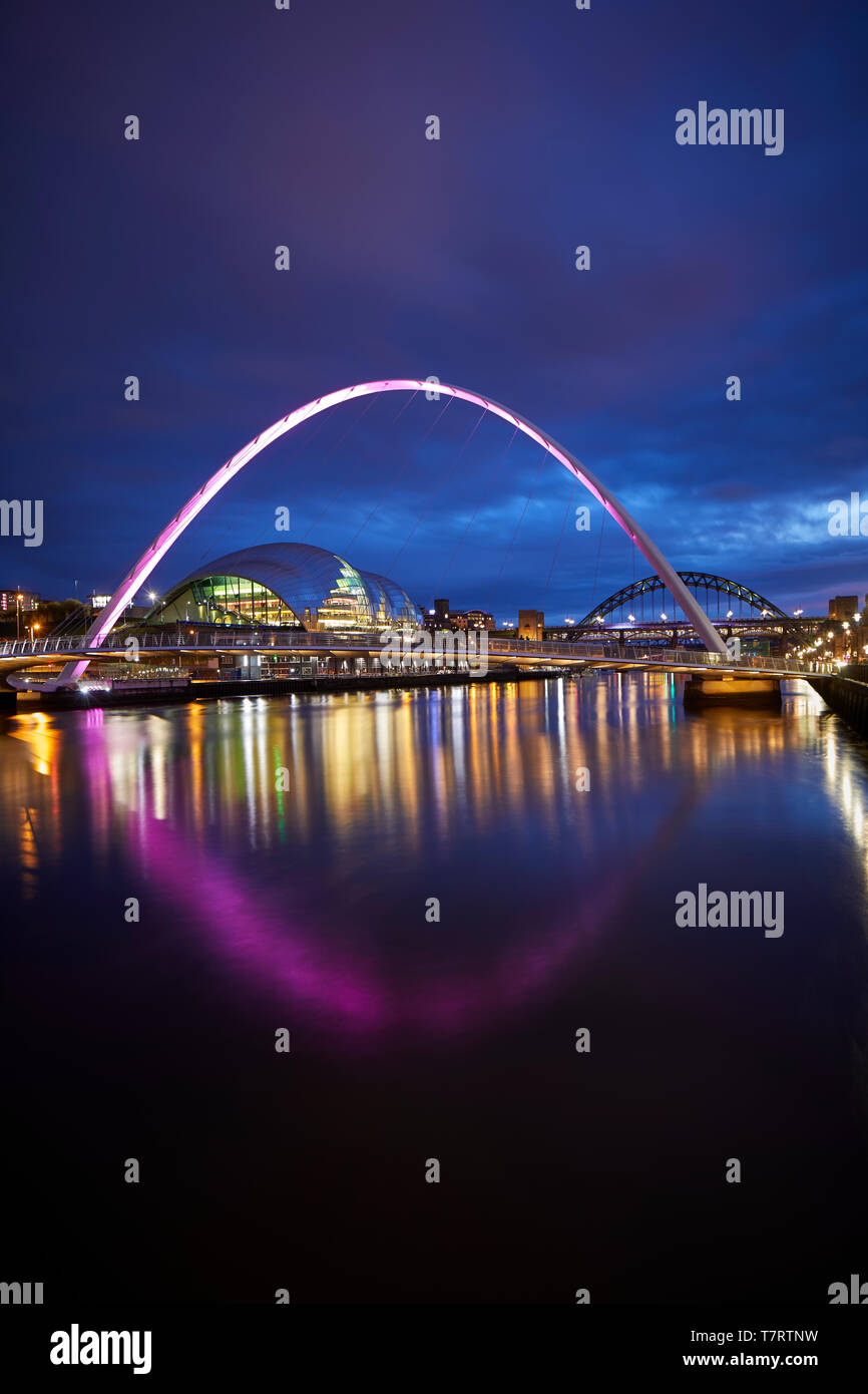 Iconic Newcastle upon Tyne Quayside waterfront landmark Millennium Bridge crossing the river Tyne and Sage Gateshead looking to the Tyne Bridge Stock Photo