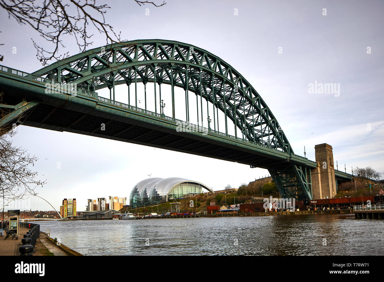 Iconic Newcastle upon Tyne  Quayside waterfront  landmark Millennium Bridge crossing the river Tyne and Sage Gateshead looking to the Tyne Bridge Stock Photo