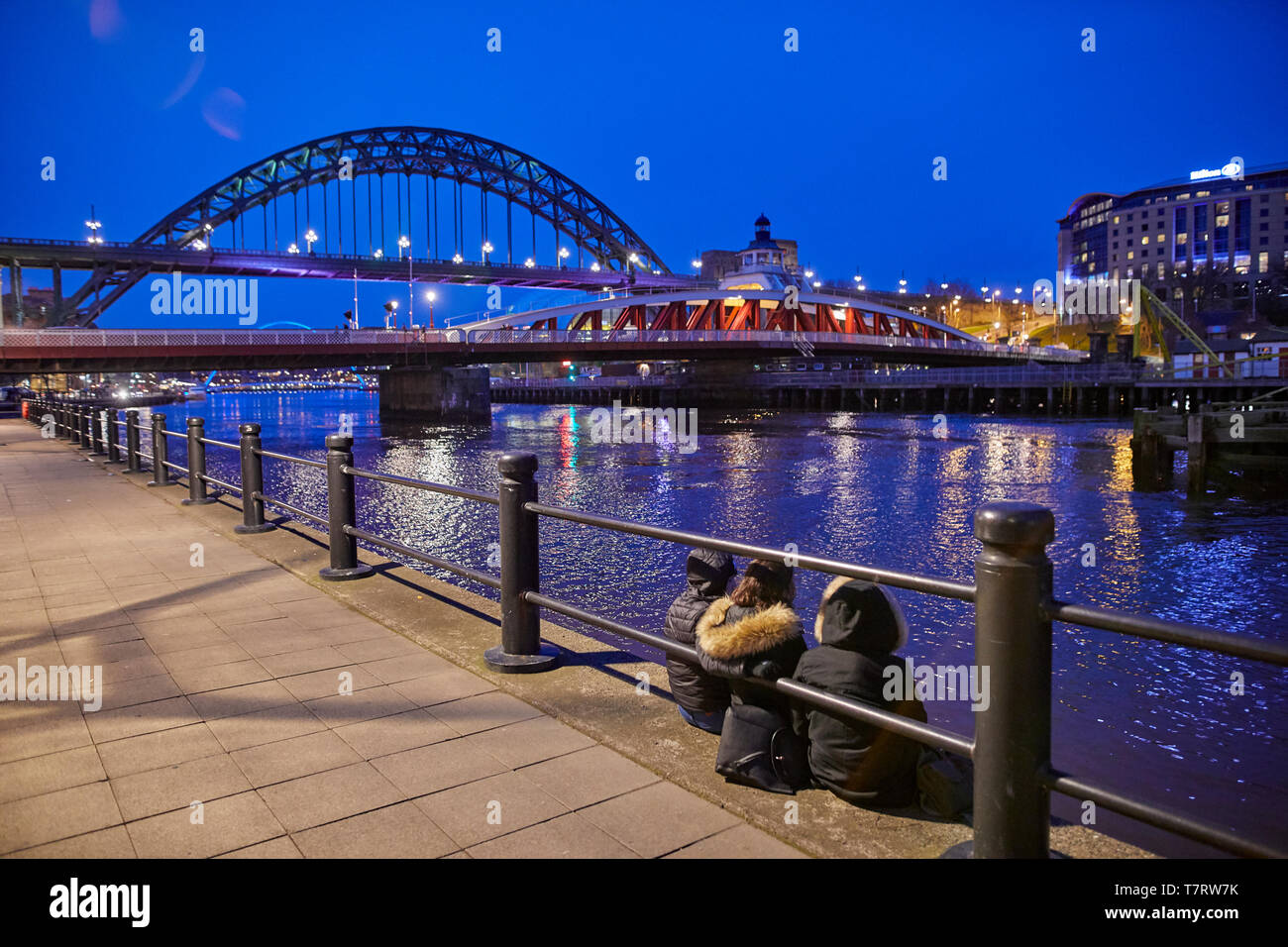 Iconic Newcastle upon Tyne  Quayside waterfront  landmark Tyne Bridge and wing Bridge crossing the river Tyne Stock Photo