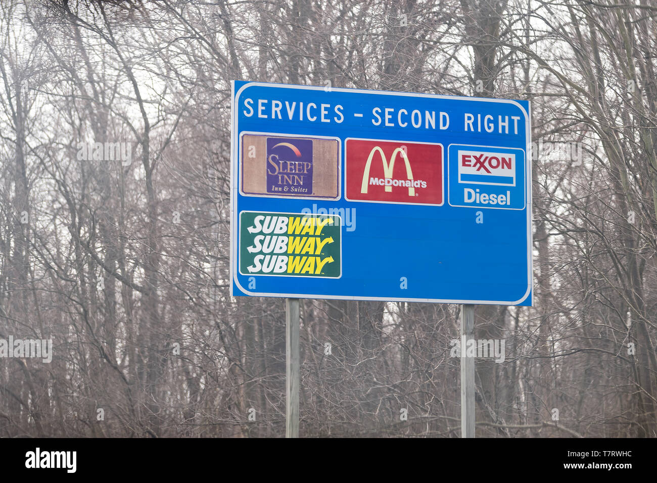 Leesburg, USA - April 6, 2018: Rural Virginia countryside in spring with blue exit sign on highway for food and service such as mcdonalds fast food, s Stock Photo