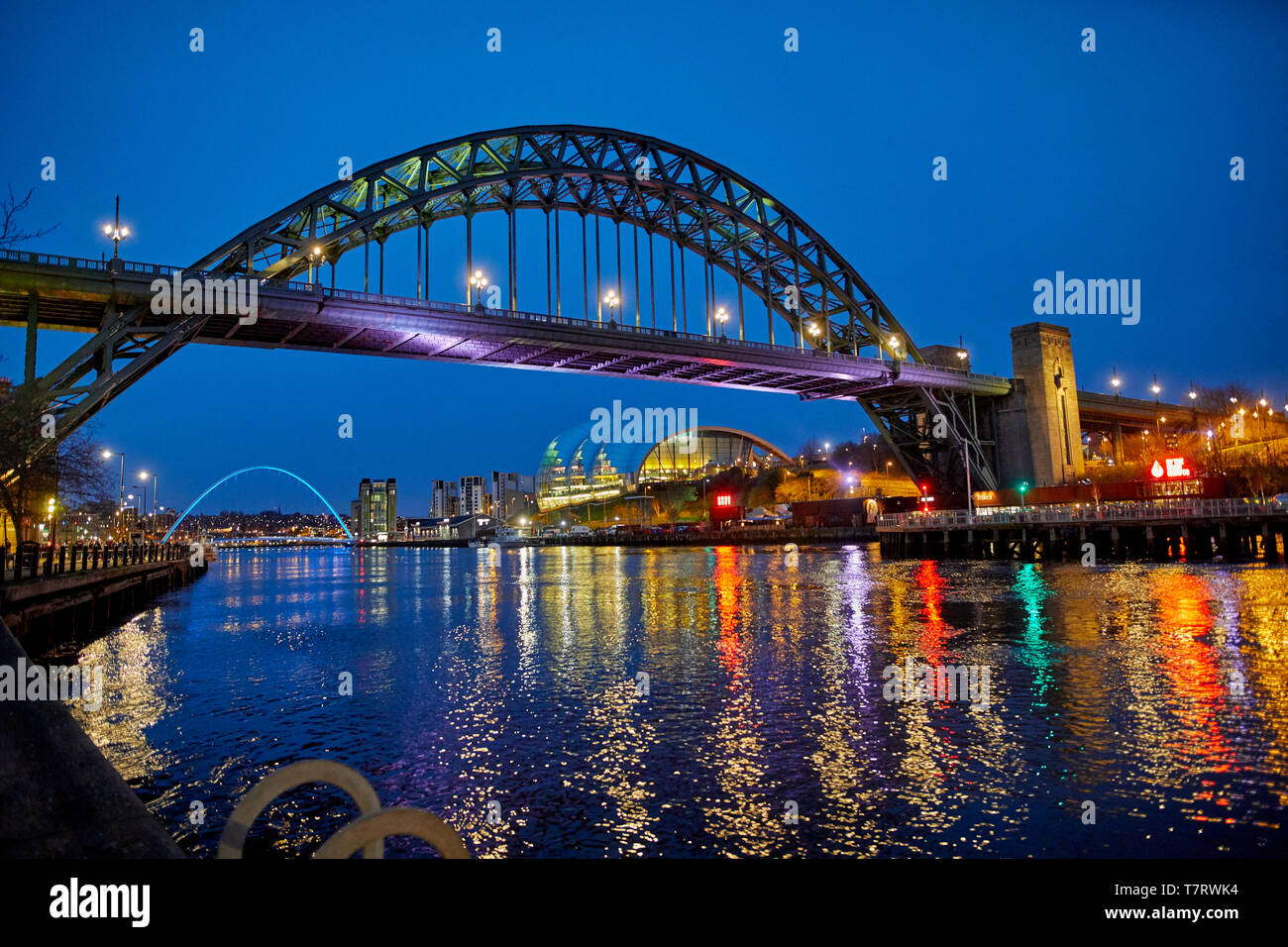 Iconic Newcastle upon Tyne  Quayside waterfront  landmark Tyne Bridge crossing the river Tyne and Sage Gateshead looking to the Tyne Bridge Stock Photo