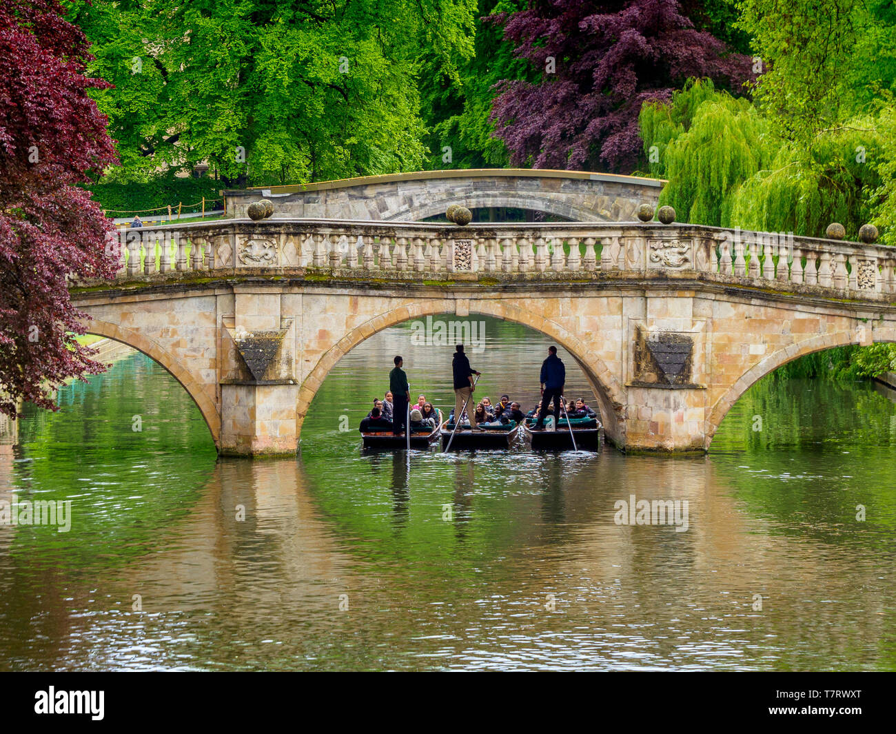 Tourists brave stormy weather to take punts along the backs alongside the historic colleges of Cambridge University. Stock Photo