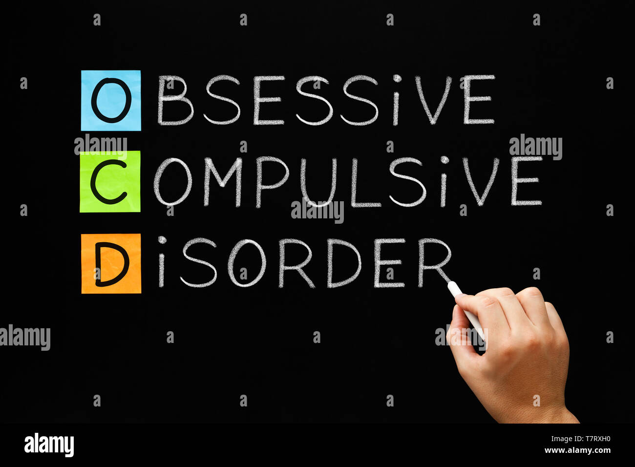 Hand writing OCD - Obsessive Compulsive Disorder with white chalk on blackboard. Stock Photo