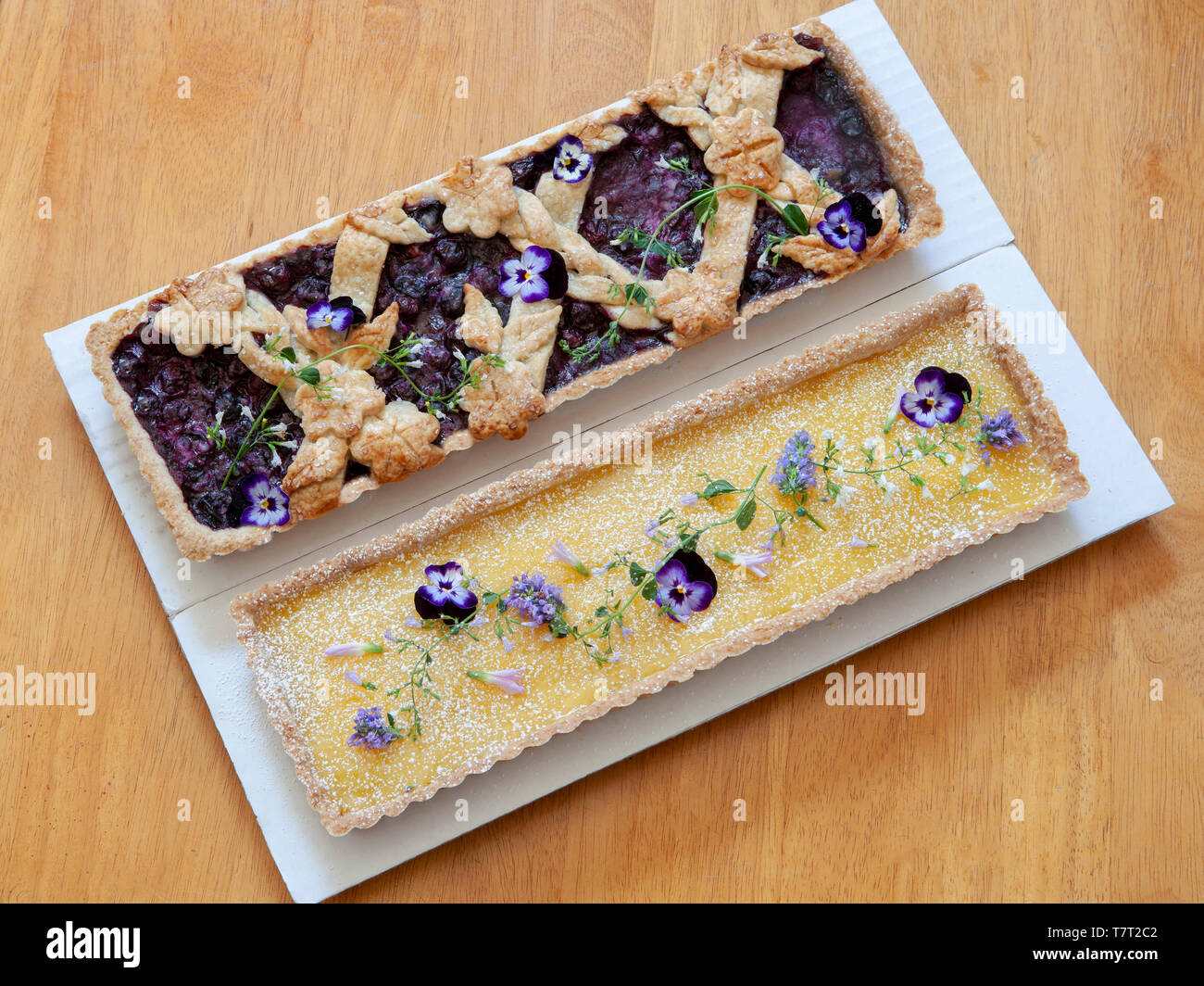 Blueberry Tart and Lemon Tart with Edible Flowers Stock Photo