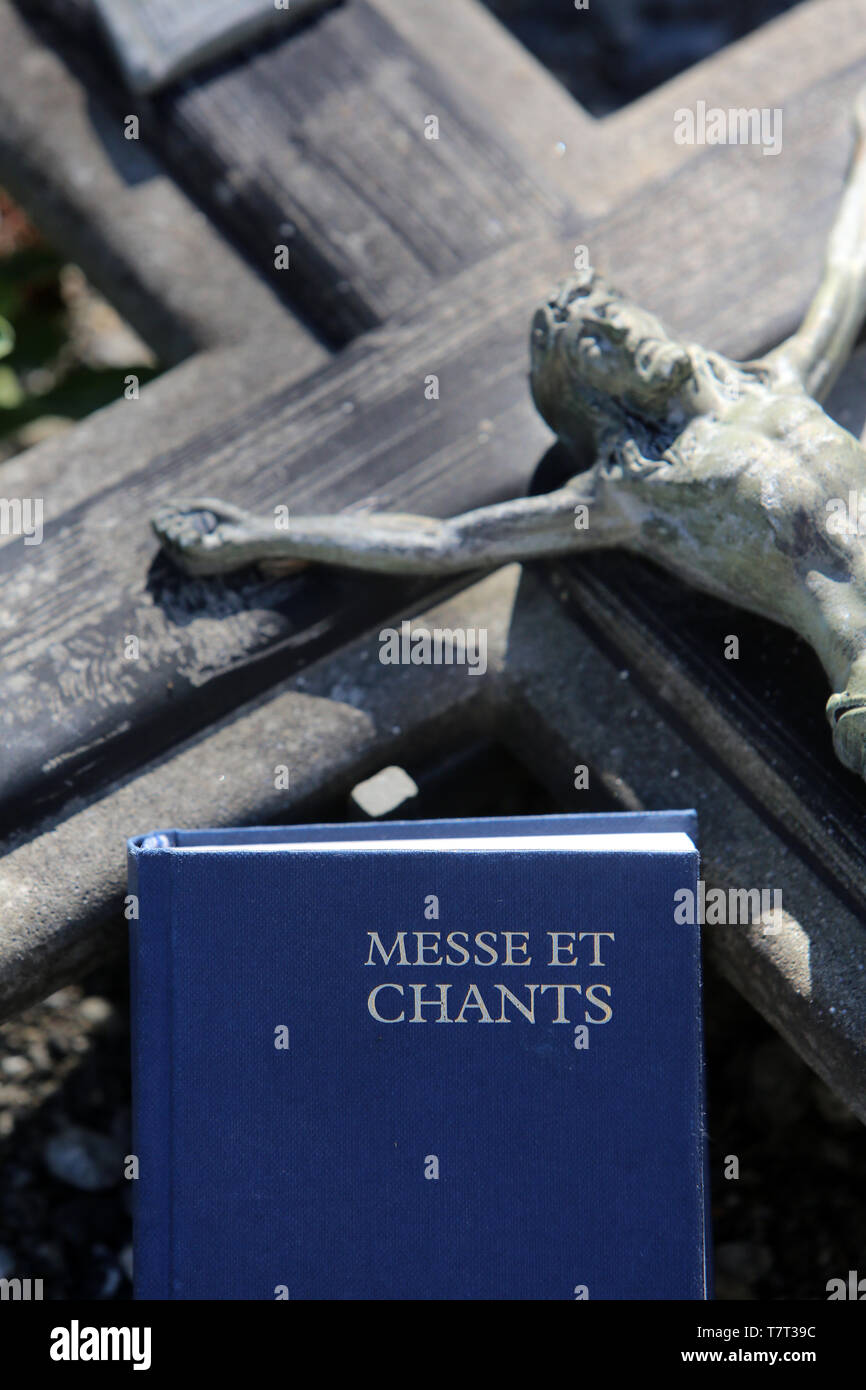 Jésus-Christ sur la croix et livre de messe et chants sur une pierre tombale. Stock Photo