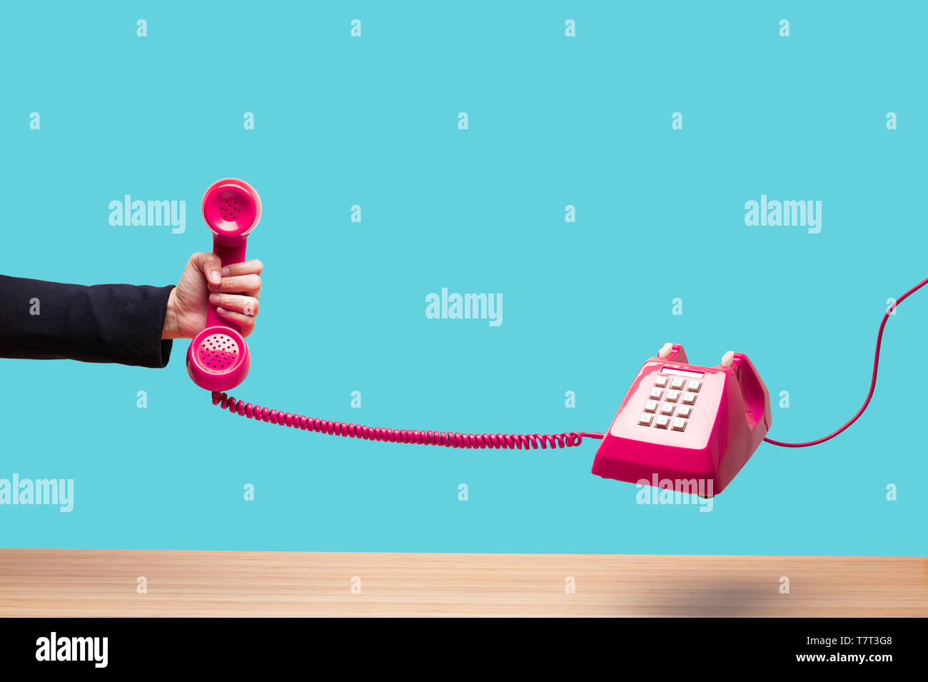 Business woman holding the red phone, urgent call waiting , classic red telephone receiver in hand wearing black suit, old telephone on white backgrou Stock Photo