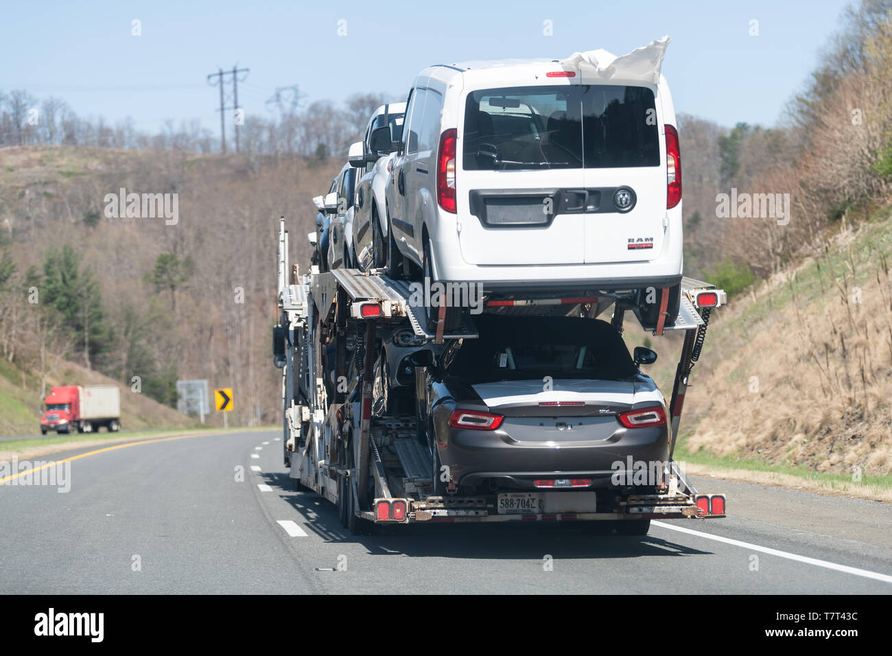 Linden, USA - April 18, 2018: Interstate highway 66 West in Virginia with cars traffic and hauler cargo truck hauling many new cars in trailer carriag Stock Photo