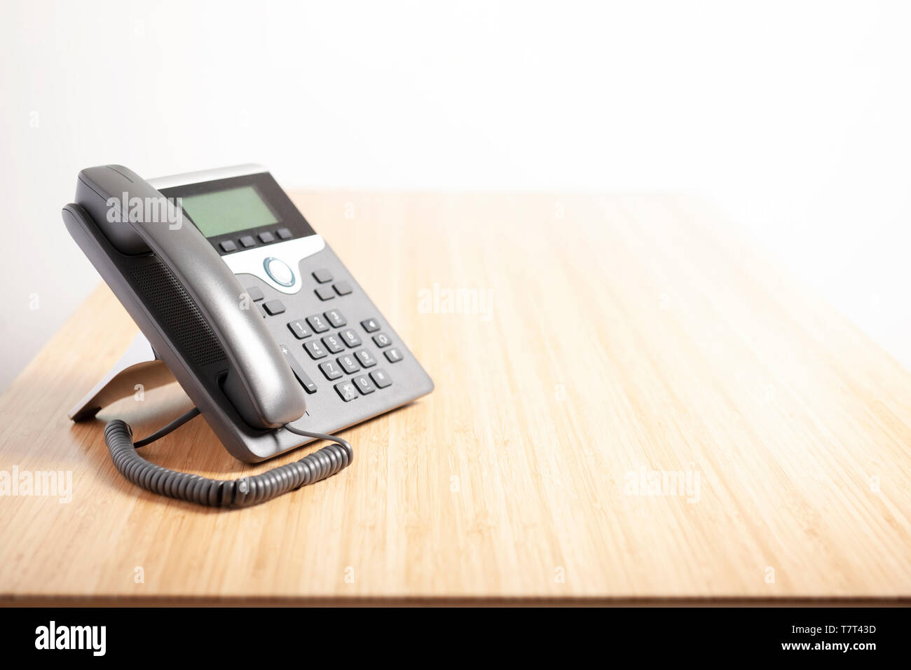 Front view of digital telephone on light wooden floor, waiting phone call. Business communication concepts Stock Photo