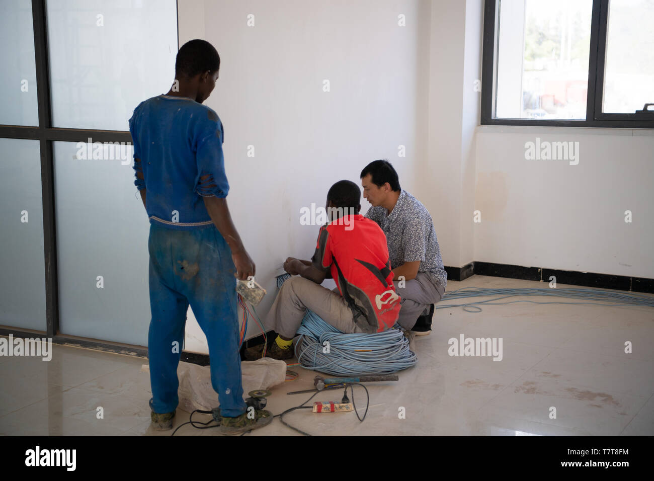 Kigali. 1st Nov, 2018. Photo taken on Nov.1, 2018 shows Chinese technician (R) and Rwandan employees working in the the Administrative Office Complex of Rwanda in Kigali, capital city of Rwanda. Implemented by China's Top International Engineering Corporation, it is the largest China-aid project in Rwanda by far. Credit: Li Yan/Xinhua/Alamy Live News Stock Photo