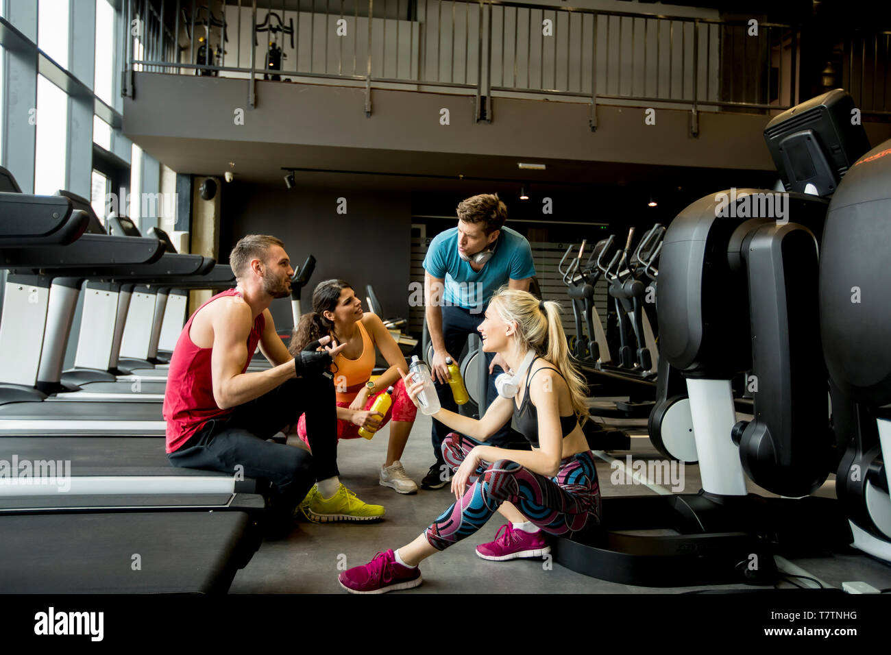  Group of young people in sportswear talking and laughing together while Illustration 