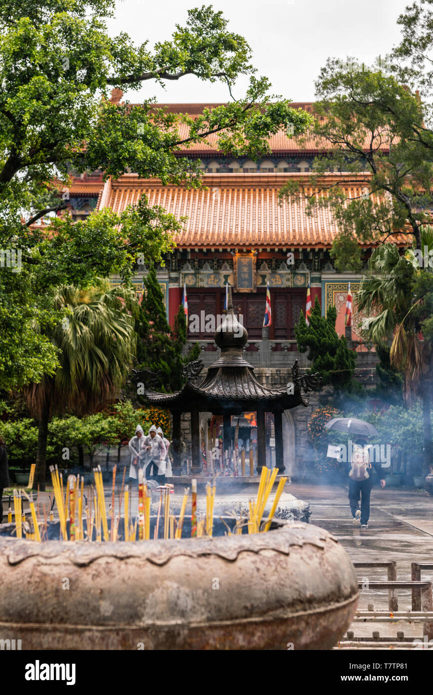 Hong Kong, China - March 7, 2019: Lantau Island. Po Lin Buddhist Monastery. Large brown stone, metal receptacle wherein incense sticks burn in front o Stock Photo