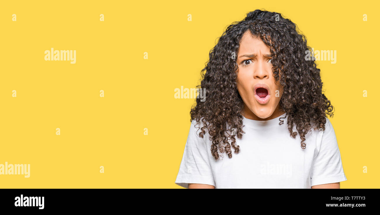 Young Beautiful Woman With Curly Hair Wearing White T Shirt In