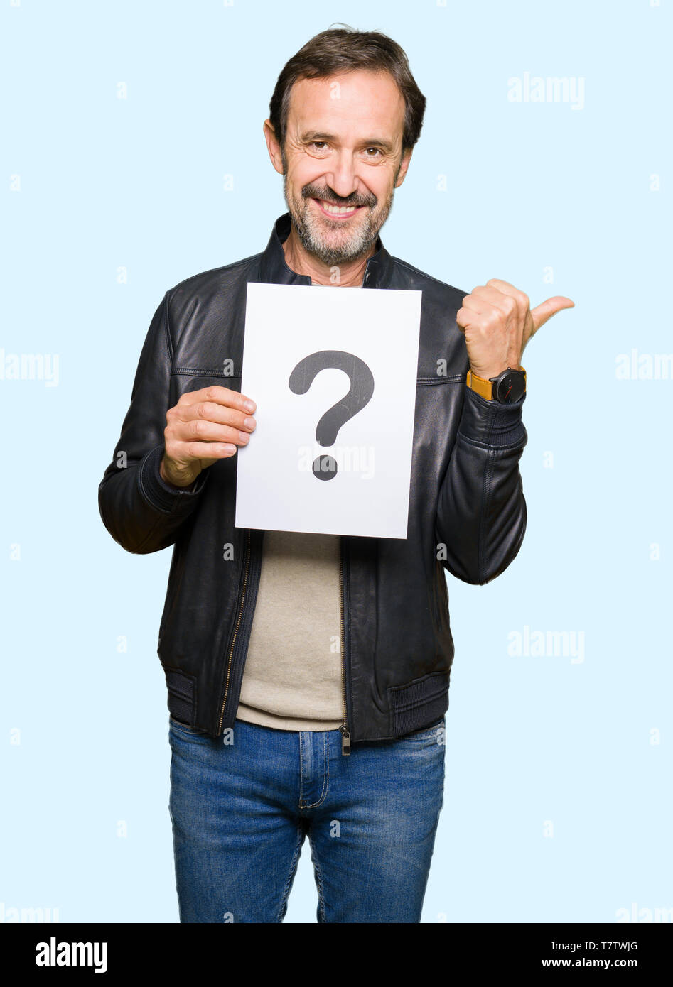 Handsome middle age man holding paper with question mark pointing and ...