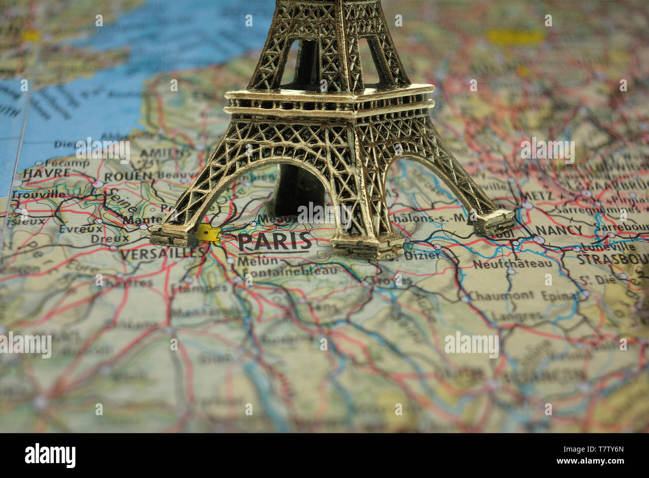 Small Eiffel tower Paris souvenir closeup on map Stock Photo