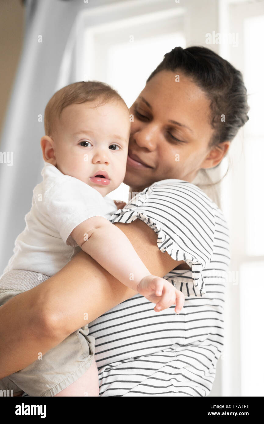 mother holds her baby (6 monthes old)  in her home in northern Philadelphia Stock Photo