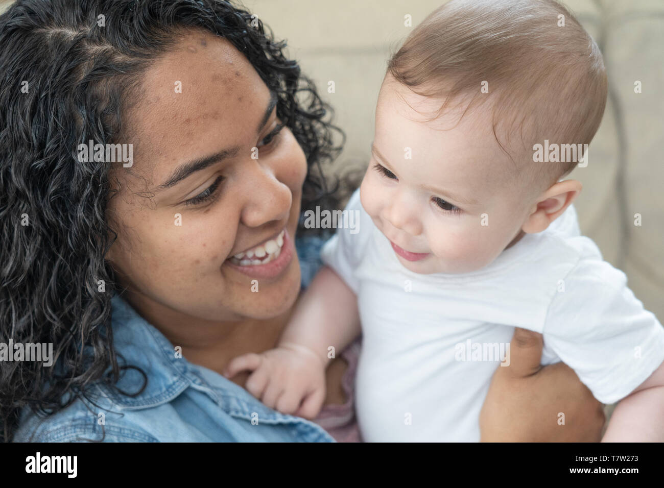 sister (15 years old) holds her baby brother (6 monthes old)  in her home in northern Philadelphia Stock Photo