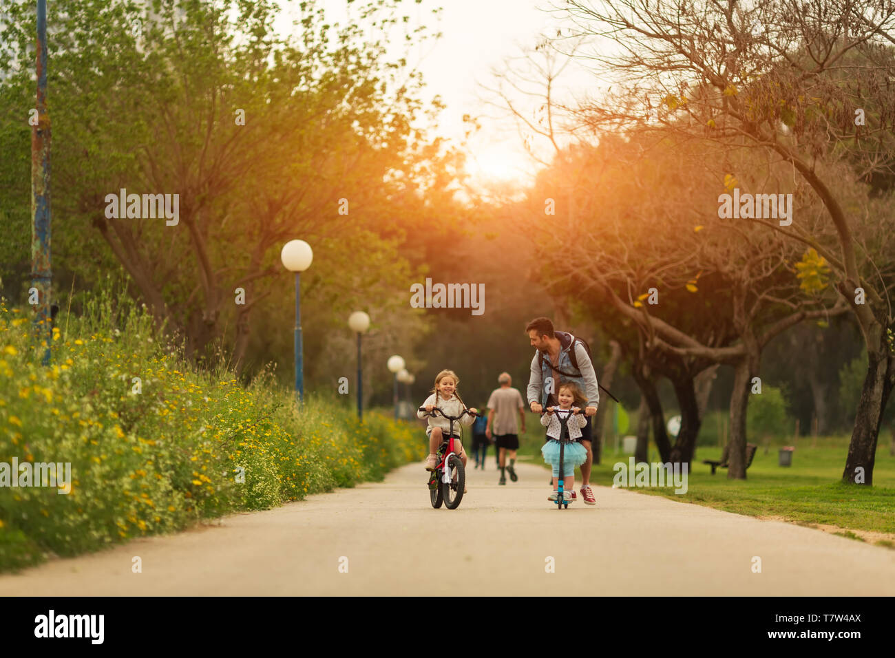 Father and daughters spending time together in park Stock Photo