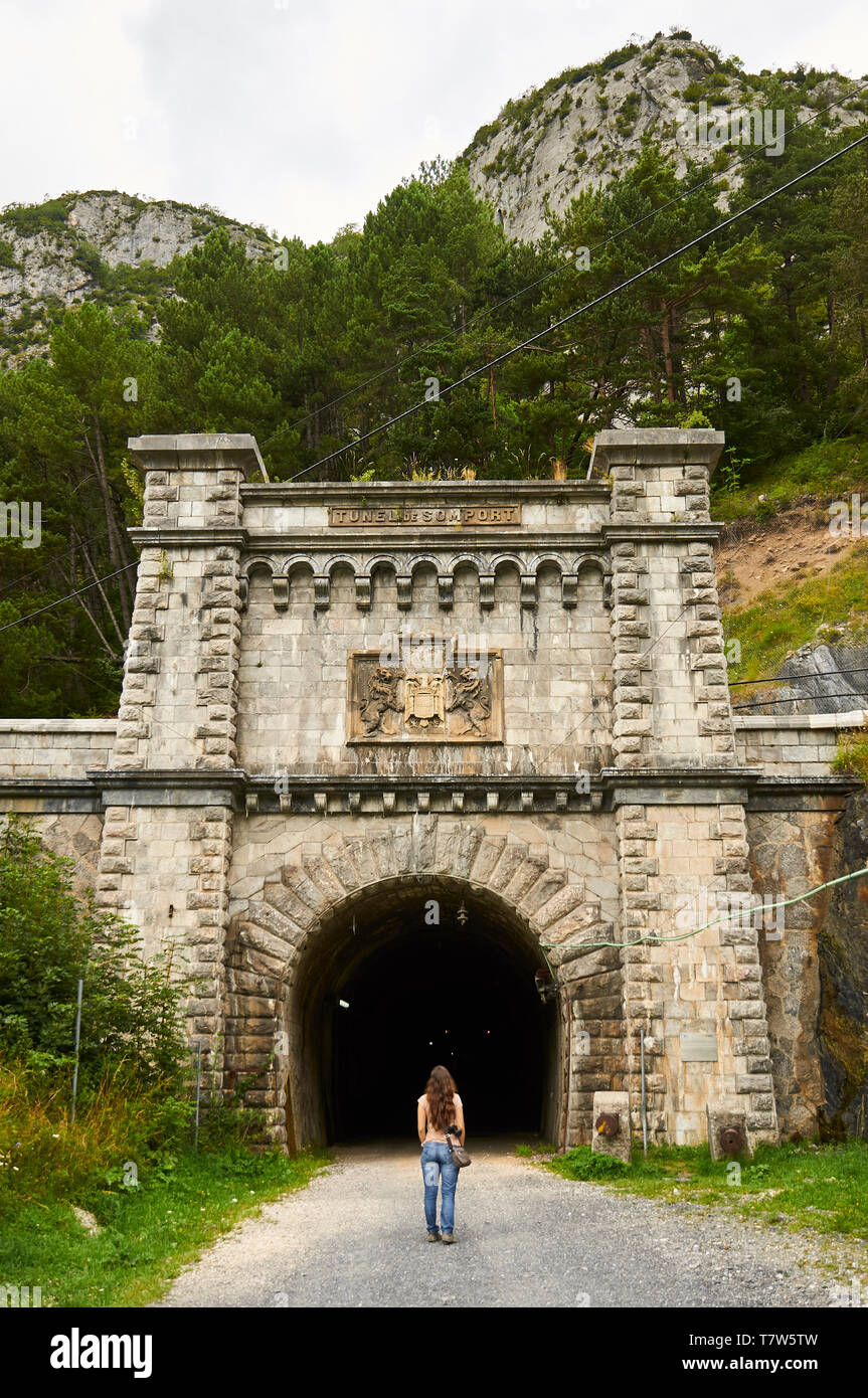 Female hiker in front of the abandoned Somport Railway Tunnel of Pau-Canfranc railway in the spanish side (Canfranc, Pyrenees, Huesca, Aragon, Spain) Stock Photo