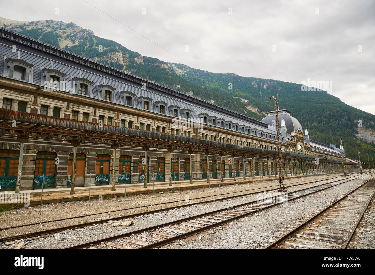 Frontage of the abandoned Canfranc International railway station and its railway tracks (Canfranc, Pyrenees, Jacetania, Huesca, Aragon, Spain) Stock Photo